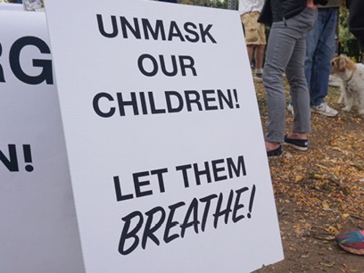 Protest sign reading Unmask our children, let them breathe, from the Foresight photobook